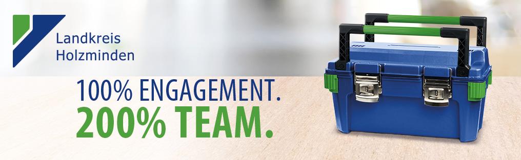 Landkreis Holzminden – 100 % Engagement, 200 % Team, mit blau-grünem Werkzeugkoffer.